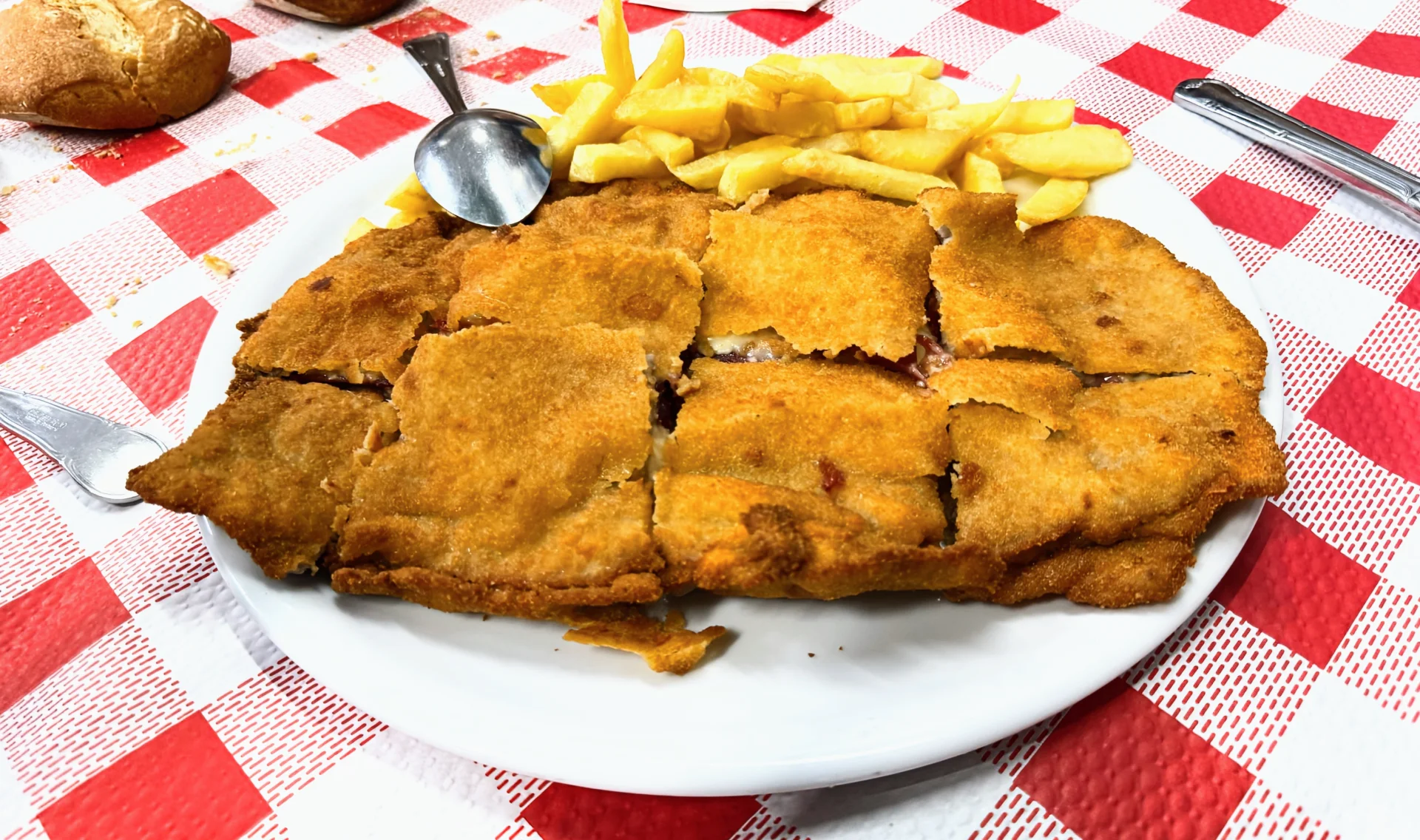 Cachopo clásico de jamón y queso con patatas fritas